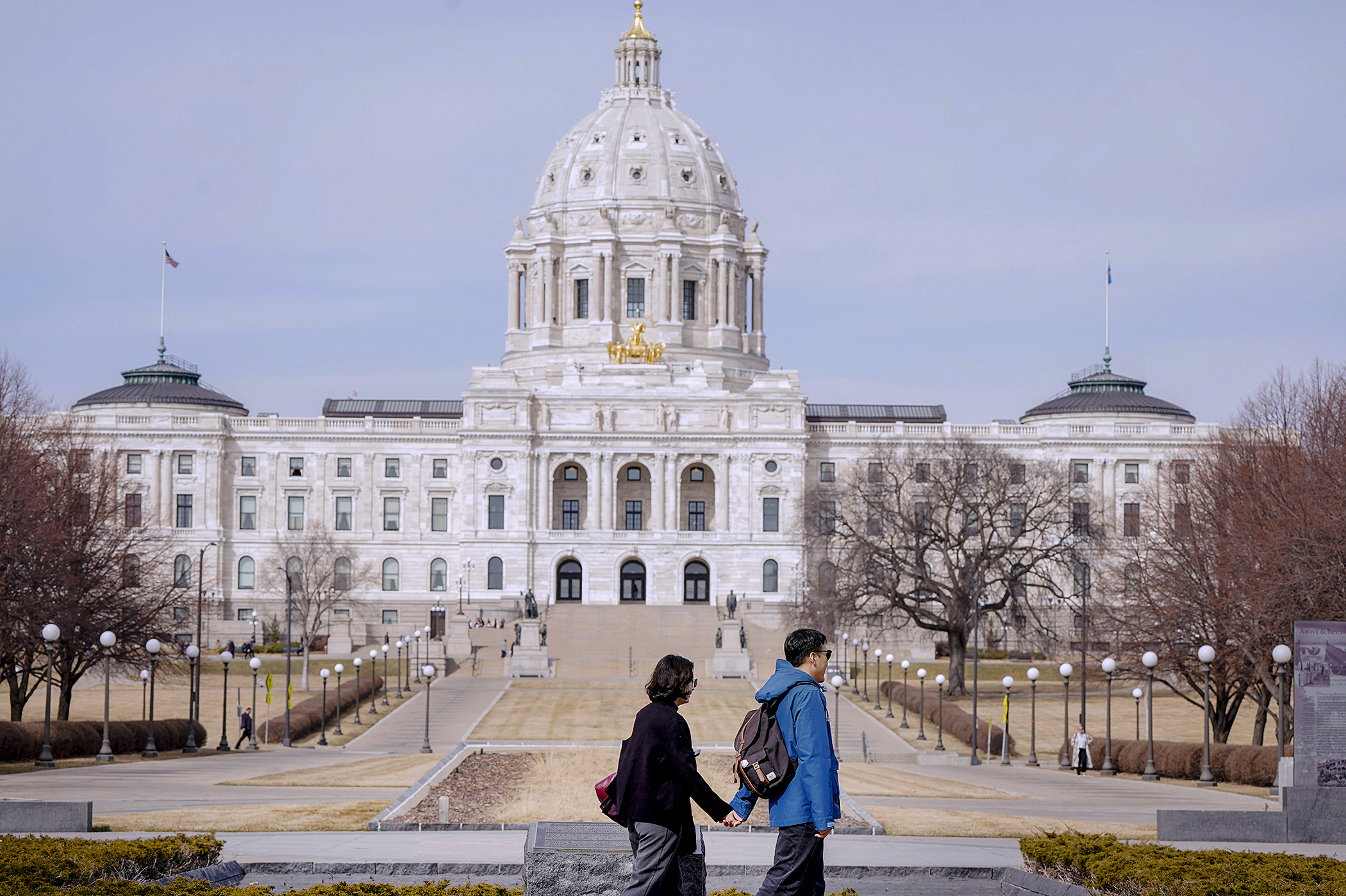 A couple walk by the World War II Memorial on the Capitol Mall March 11. (Photo by Michele Jokinen)